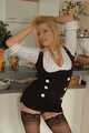 Pierced mature blonde Nina posing in a tight businessdress and stockings in front of the kitchen 5